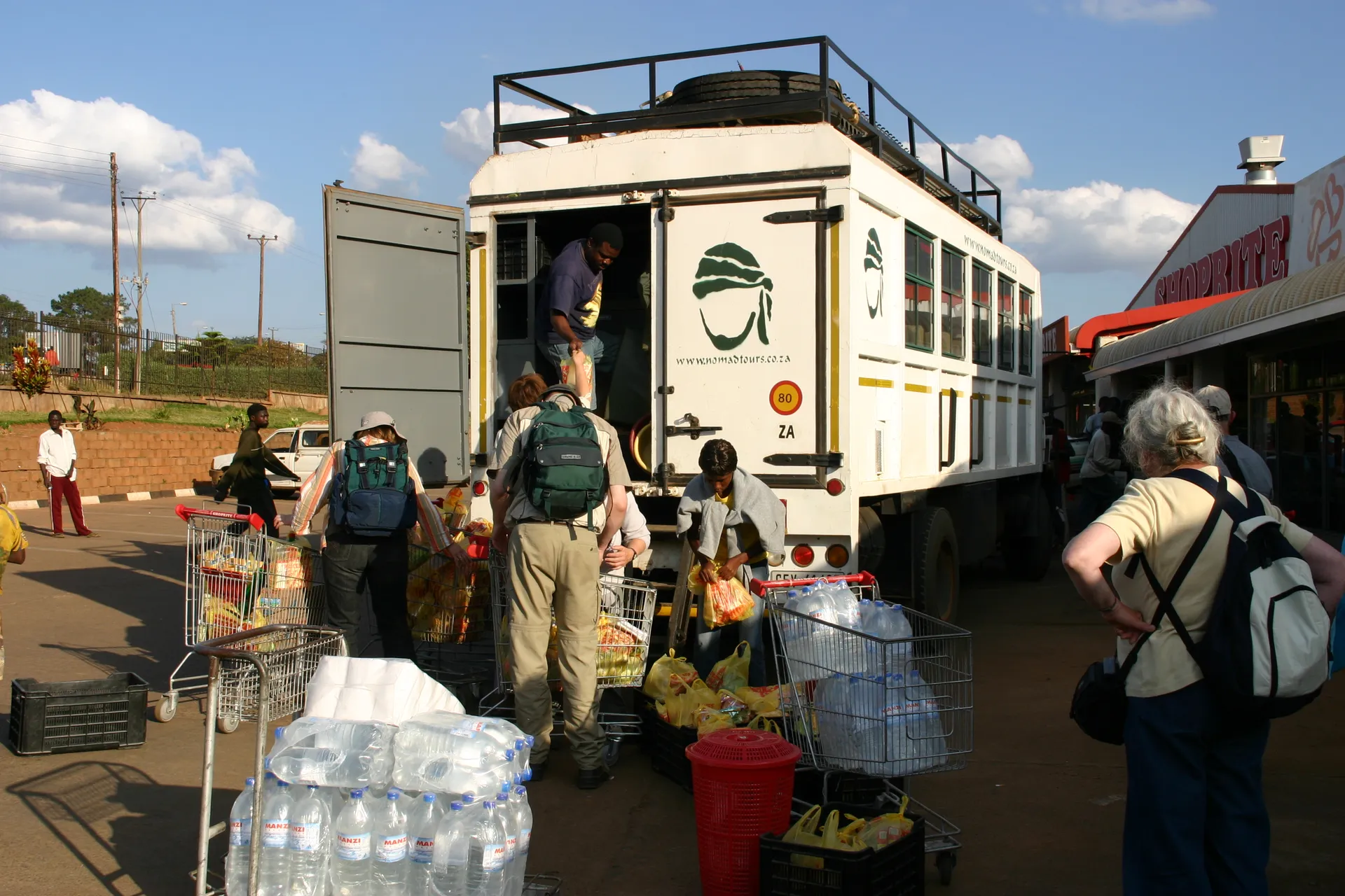 Inladen van de boodschappen in de ruimte voor proviand achterin de truck [Chipata]