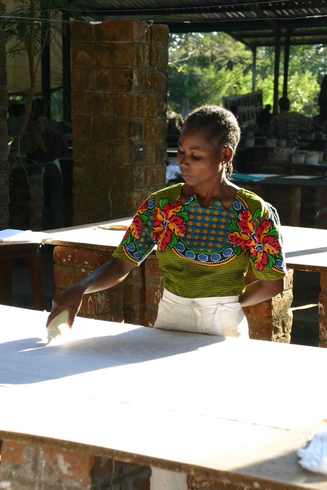 Uit de losse hand tekent deze vrouw lijnen met een stijfselpapje [<i>Tribal Textiles</i>, Mfuwe]