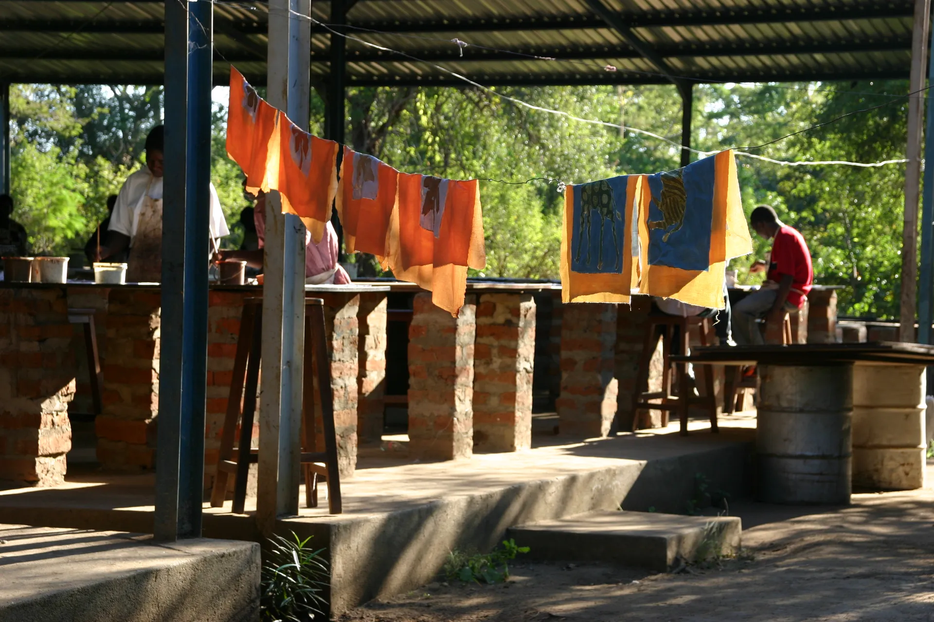 Na het inkleuren van de vlakken met verf hangen de lappen te drogen [<i>Tribal Textiles</i>, Mfuwe]