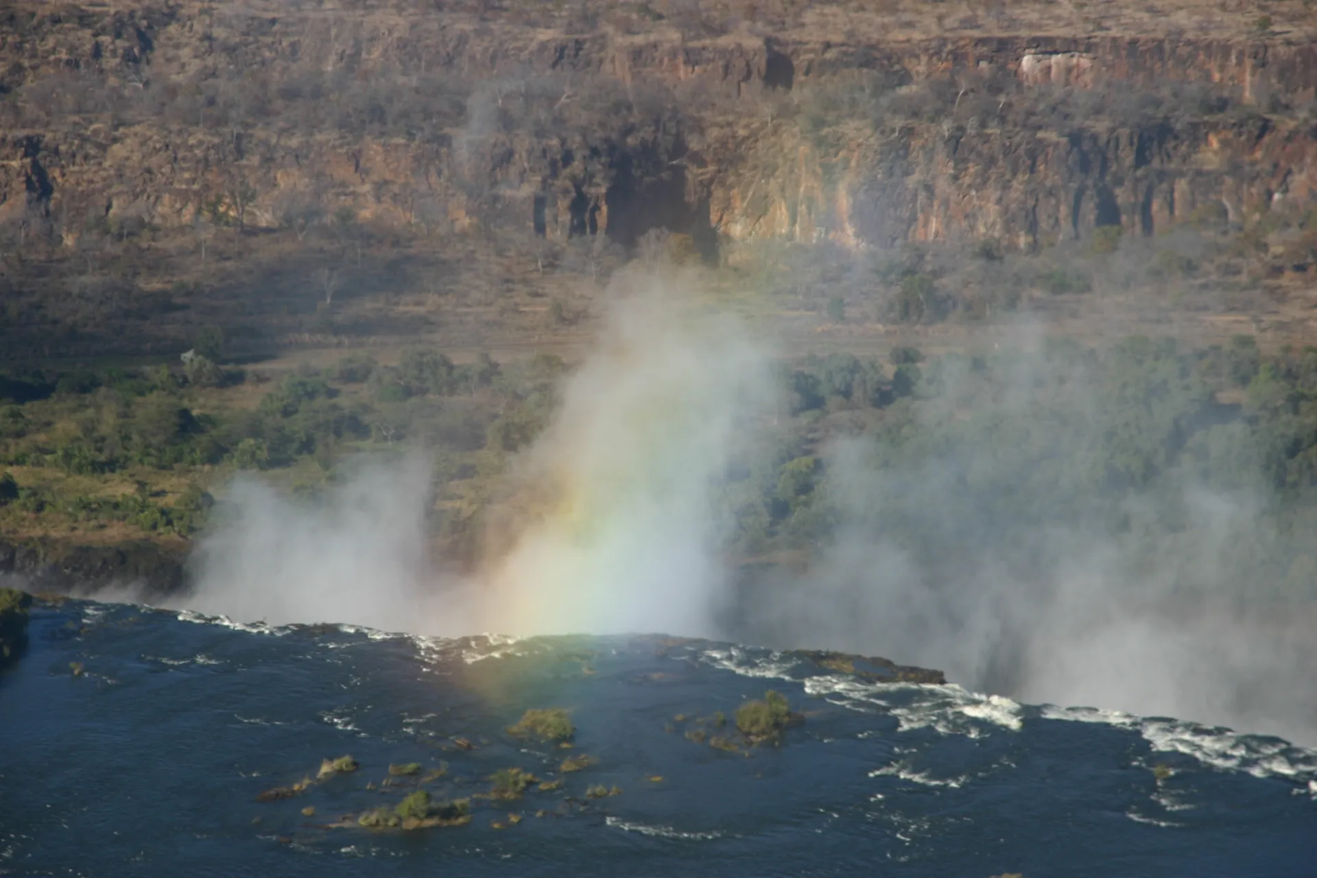 Een regenboog brengt kleur in de waternevels [Victoria watervallen]