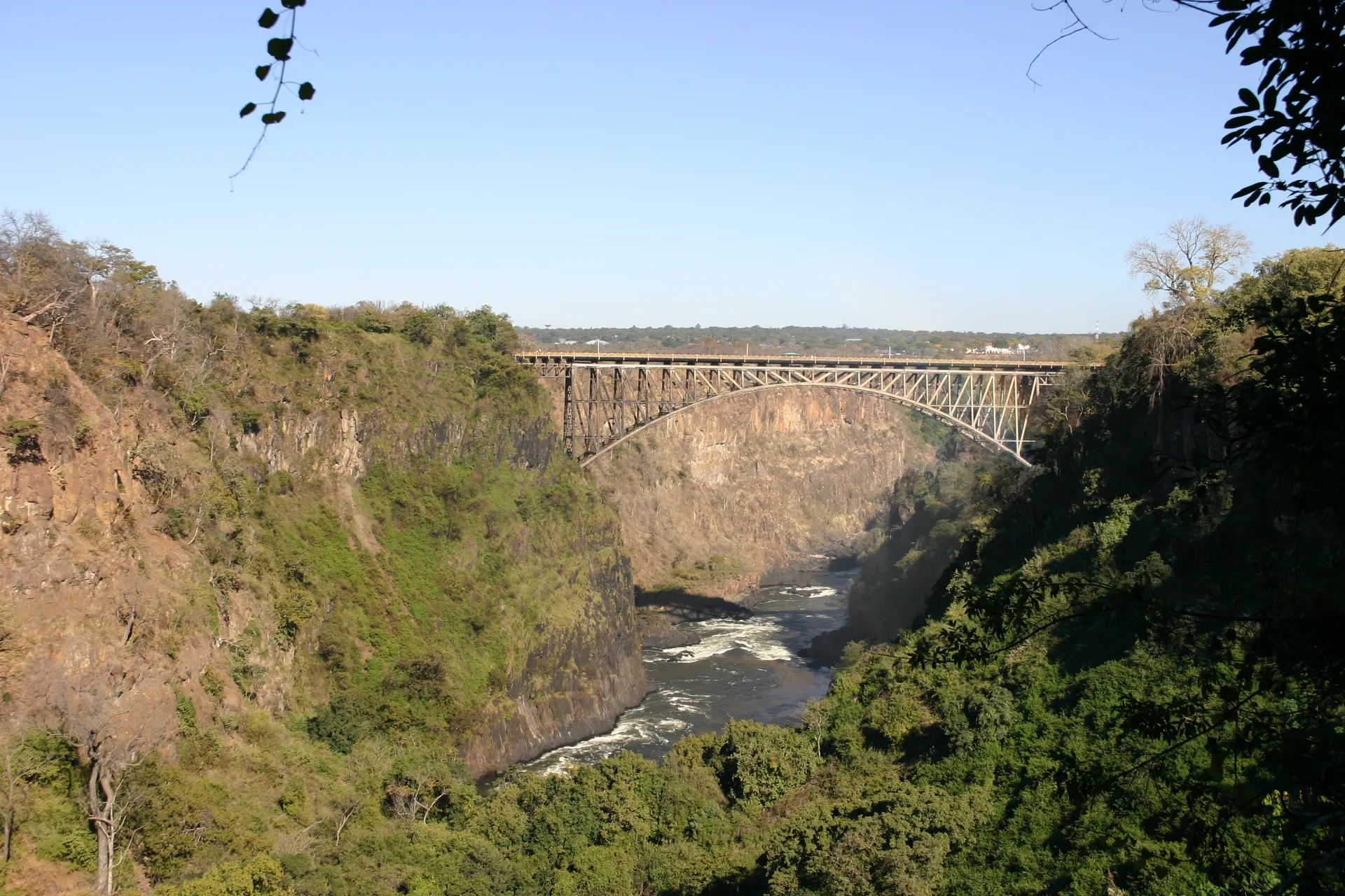 Victoria Falls Bridge over de Batoka kloof, gebouwd in 1905, nu de verbinding tussen Zambia (links) en Zimbabwe (rechts)