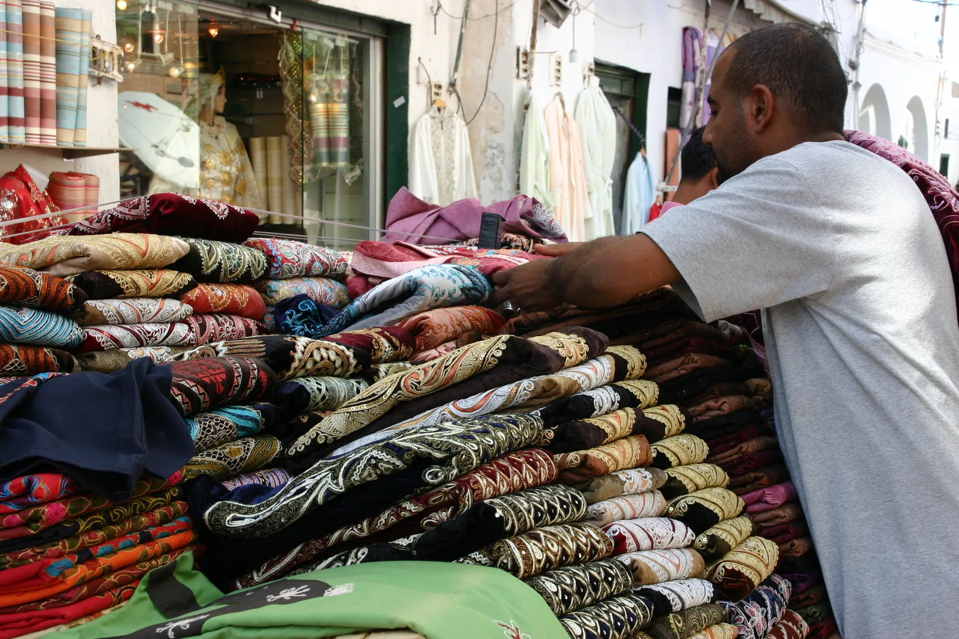 Kleurige djellaba´s in een marktstalletje op straat [Tripoli, medina]
