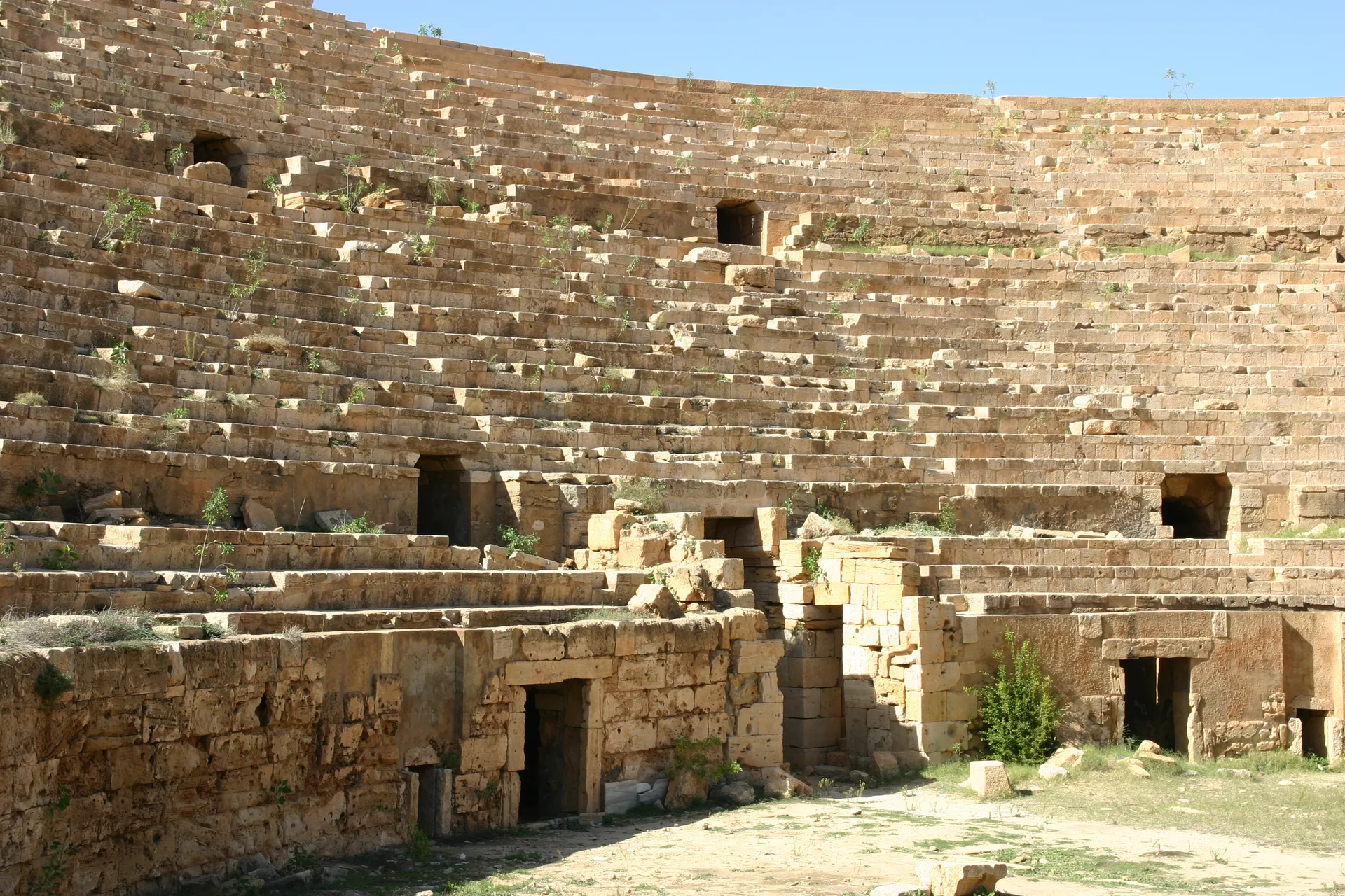 Rondom liggen toegangen vanuit de catacomben naar de arena van het amfitheater [Leptis Magna]