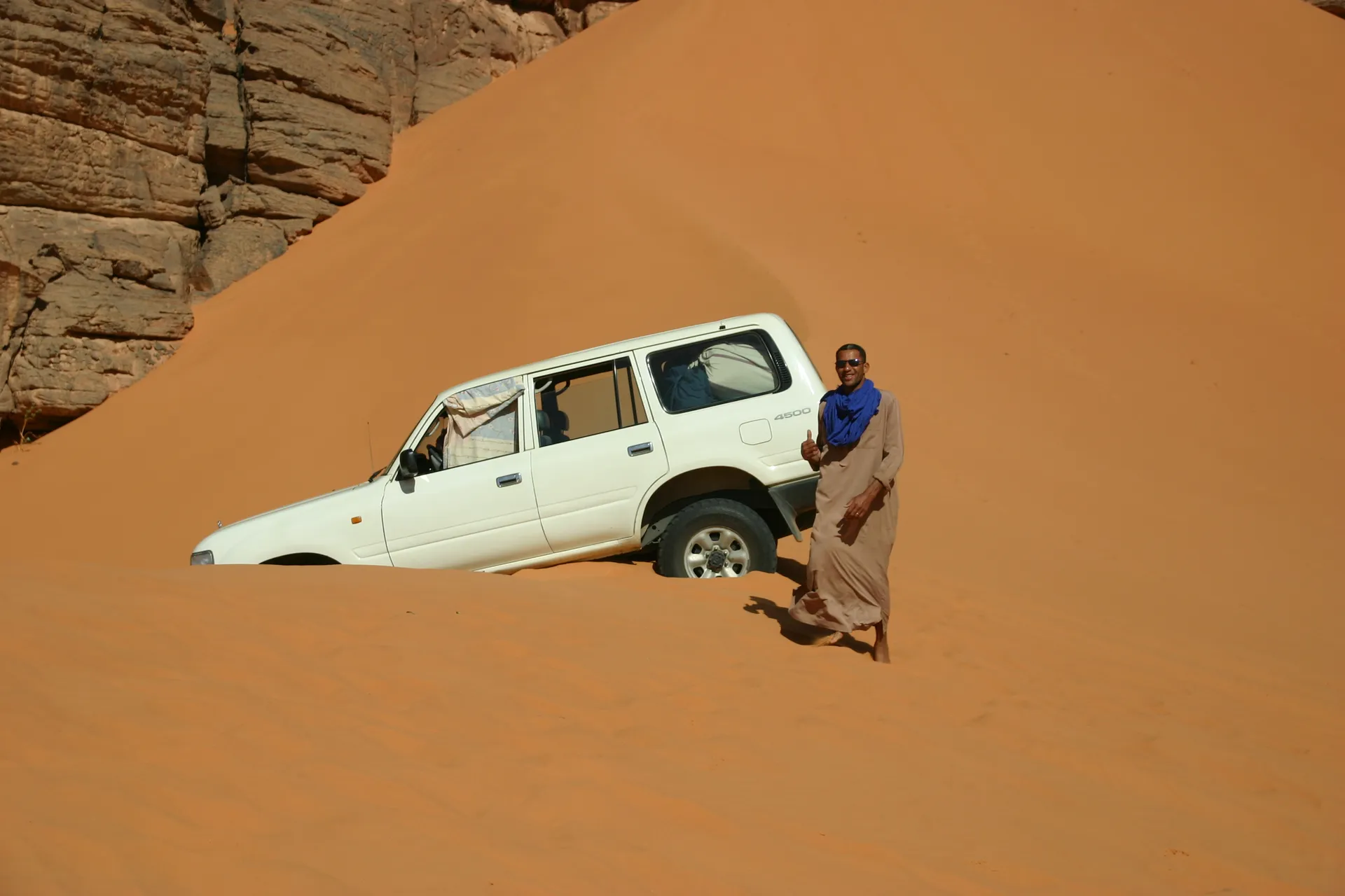 Onze witte auto beklimt een steil zandduin als eerste ... [Akakus gebergte]