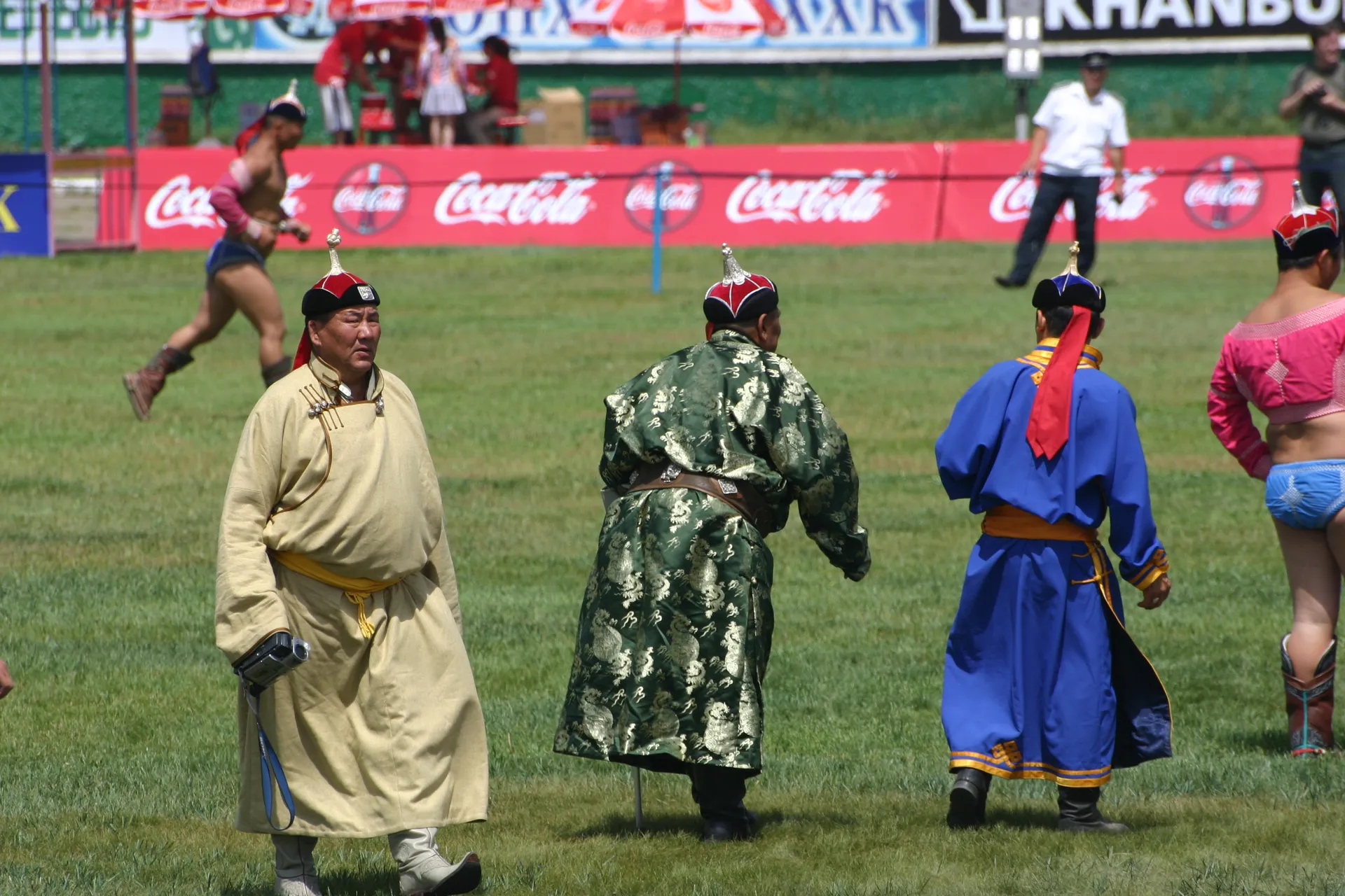 Een official bij de worstelwedstrijden, in traditionele <i>del</i> maar wel met videocamera [Naadam festival, Ulaanbaatar]